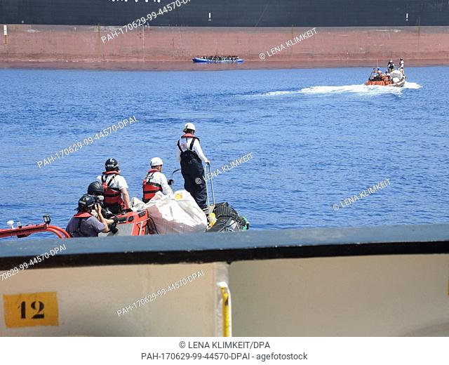 Boats from the ""Aquarius"" rescue ship sail in the Mediterranean towards a rubber dinghy on board which refugees sit, 27 June 2017
