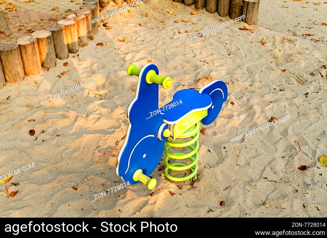 Photo of a blue rocking horse in the playground