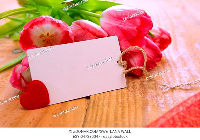 Pink tulip bouquet and blank greeting card. Pink tulips with card on wood background