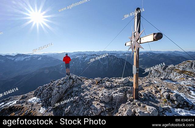 Mountaineer at the summit of the Guffertspitze, summit with summit cross, sun star, in autumn, Brandenberg Alps, Tyrol, Austria, Europe