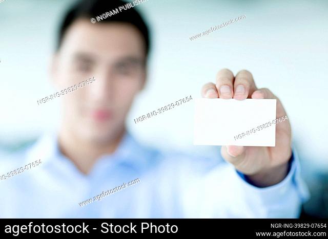 Young businessman holding business card to the camera