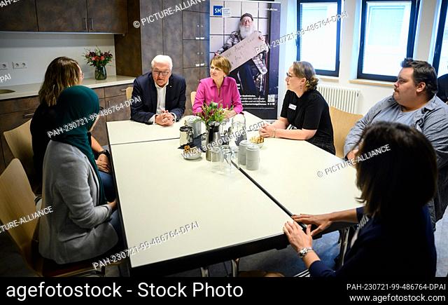 21 July 2023, Berlin: German President Frank-Walter Steinmeier (center l) and his wife Elke Büdenbender (center r) chat with staff during a visit to the Zentrum...