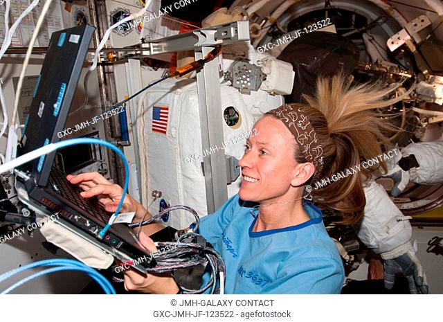 NASA astronaut Karen Nyberg, Expedition 36 flight engineer, uses a computer in the Quest airlock of the International Space Station
