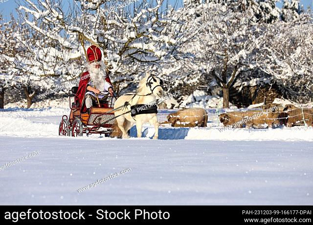 03 December 2023, Baden-Württemberg, Bad Saulgau: A man dressed as St. Nicholas is on his way to a St. Nicholas party on the first Advent in a carriage pulled...
