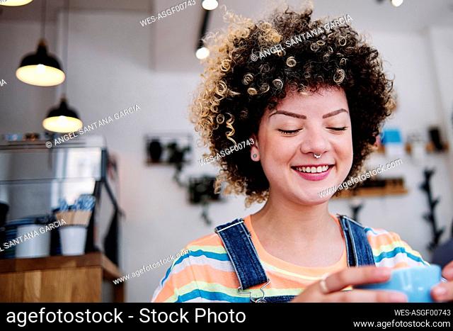 Smiling woman holding cup at cafe