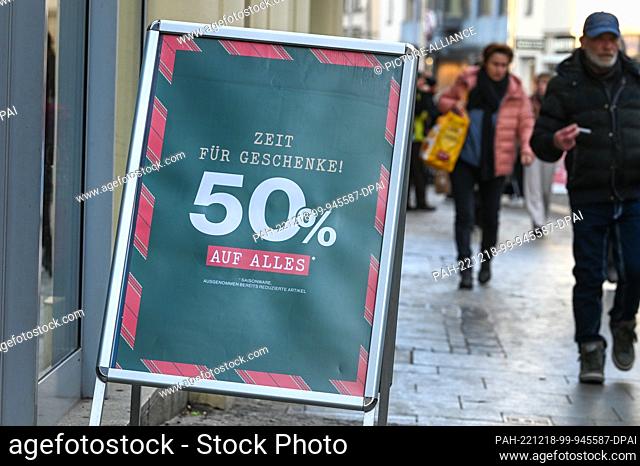 18 December 2022, Saxony-Anhalt, Halle (Saale): A display in front of a store advertises discounts on Christmas shopping