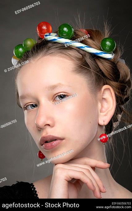 Portrait of a funny teenage girl with a wreath of sweets on her head