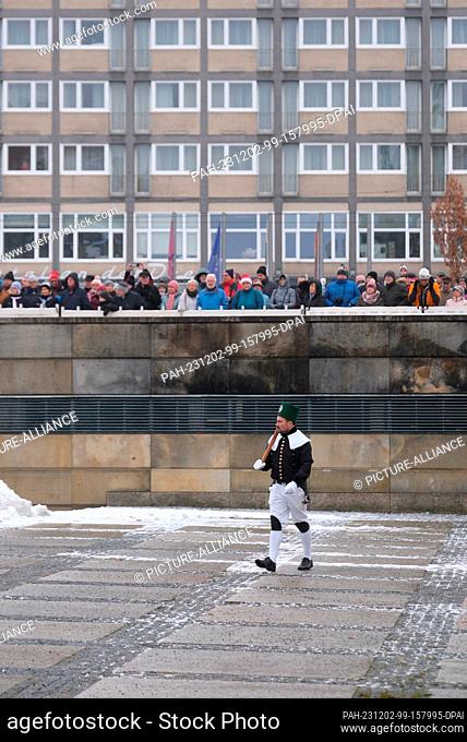 02 December 2023, Saxony, Chemnitz: A participant in a mountain parade walks across the still empty Theaterplatz. On the eve of the first Advent