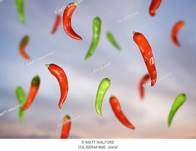 Composite still life of floating red and green chillies