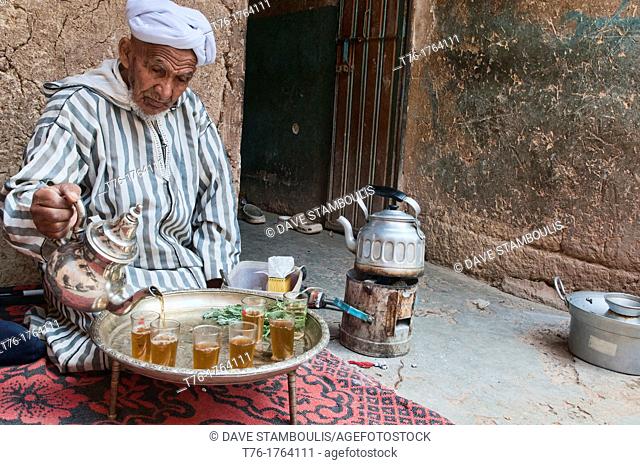 traditional Berber grandfather pouring tea in the Southern Atlas Mountains, Morocco
