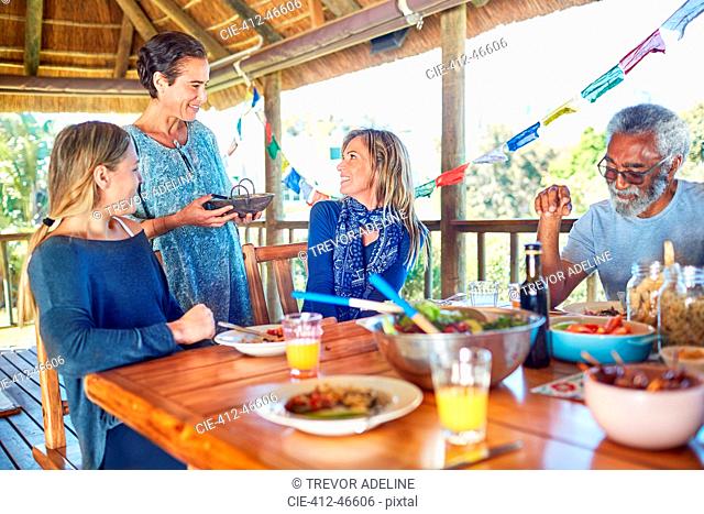 Friends enjoying healthy meal in hut during yoga retreat
