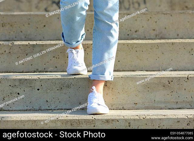 Front view close up of a woman legs wearing sneakers walking down stairs