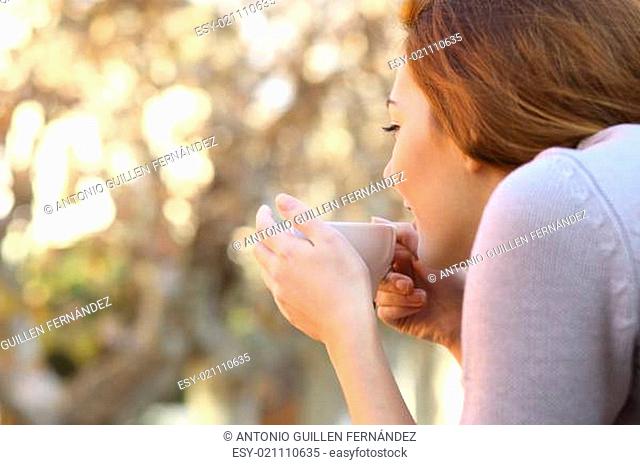 Relaxed woman holding a cup of coffee outdoor