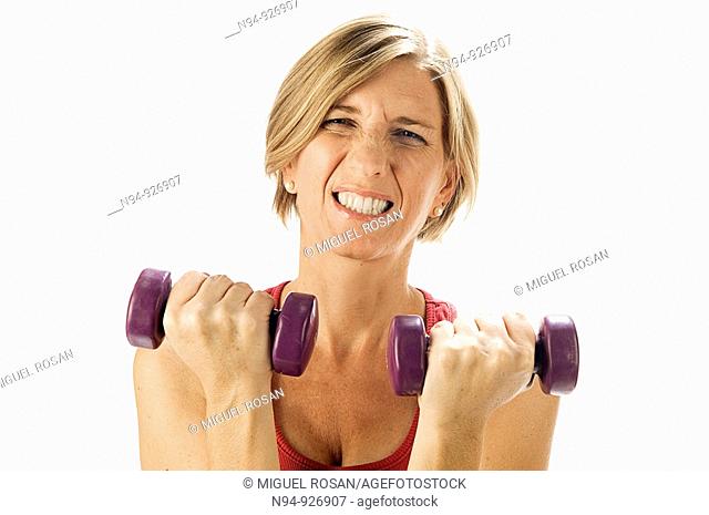Young woman, blonde, exercising with weights in the gym to get fit