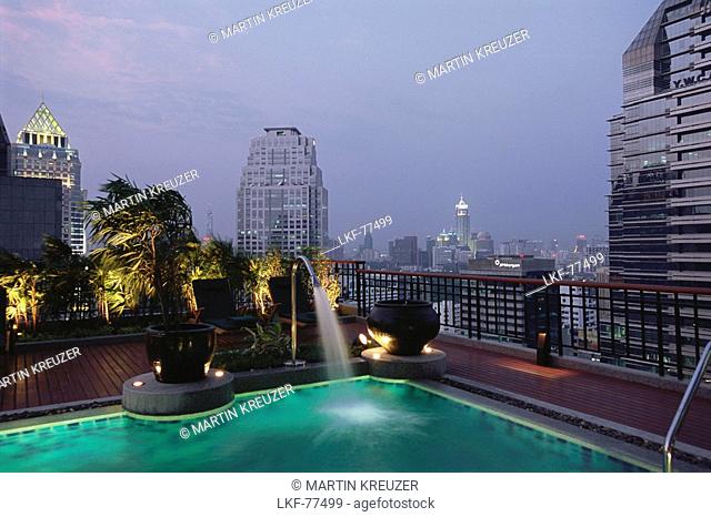 Cityscape of Bangkok in the evening, with swimming pool of Hotel Banyan Tree Spa in the foreground, Bangkok, Thailand