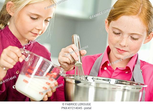 Two girls cooking food in the kitchen