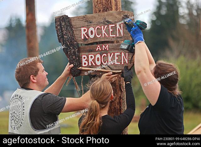 01 August 2023, Saxony-Anhalt, Elend: Sign ""Rocken am Brocken"" is mounted on a festival meadow in Elend. For the festival ""Rocken am Brocken"" , from 3