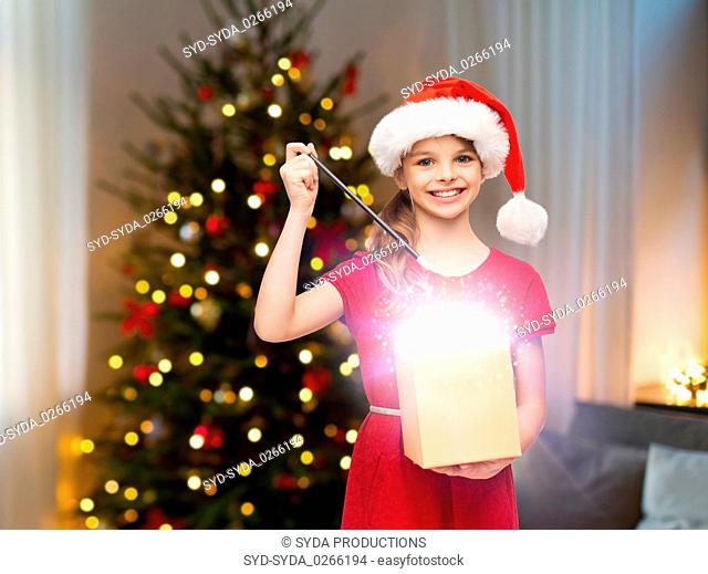 smiling girl with christmas gift and magic wand