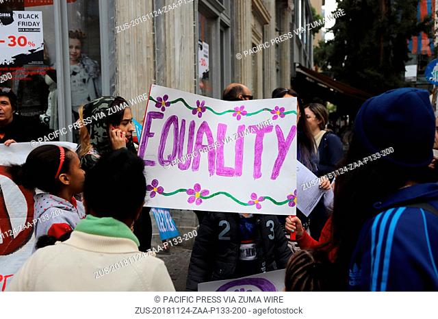 November 24, 2018 - Athens, Attiki, Greece - Refugees hold a sign with 'Equality' written on it..Feminists and women rights activists demonstrate in Athens in...