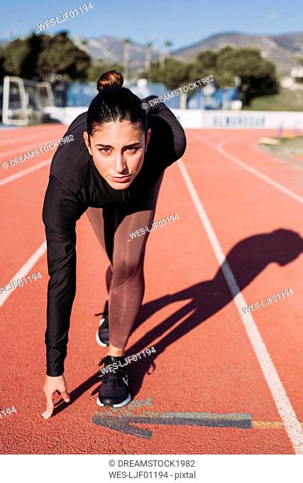 Young woman on tartan track starting