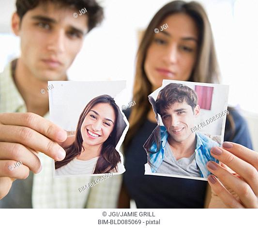 Couple holding torn photograph