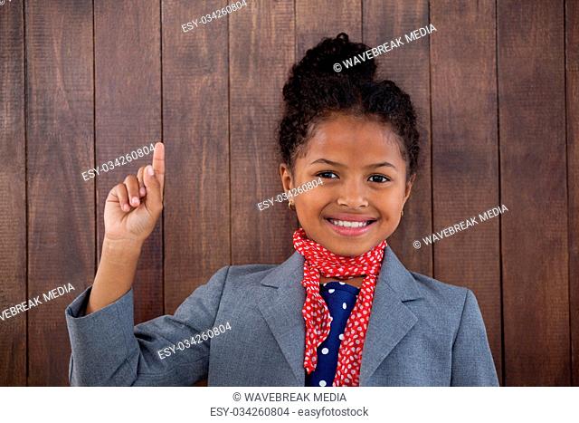 Portrait of happy businesswoman pointing upwards