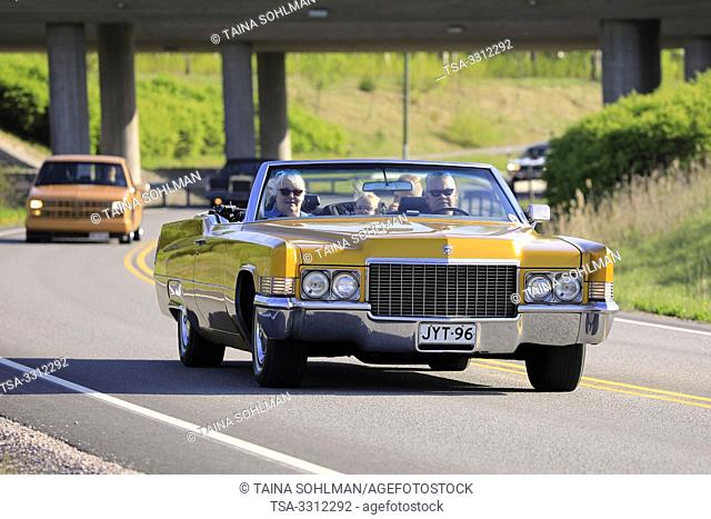 Salo, Finland. May 18, 2019. People cruising on classic yellow 1970s Cadillac convertible along highway on Salon Maisema Cruising 2019