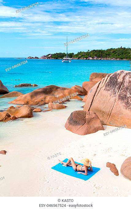Woman sunbathing at Anse Lazio picture perfect beach on Praslin Island, Seychelles