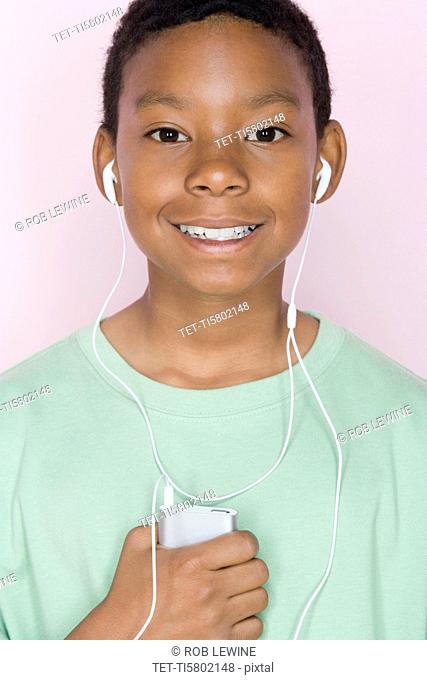 Studio shot portrait of young man with mp3 player, head and shoulders