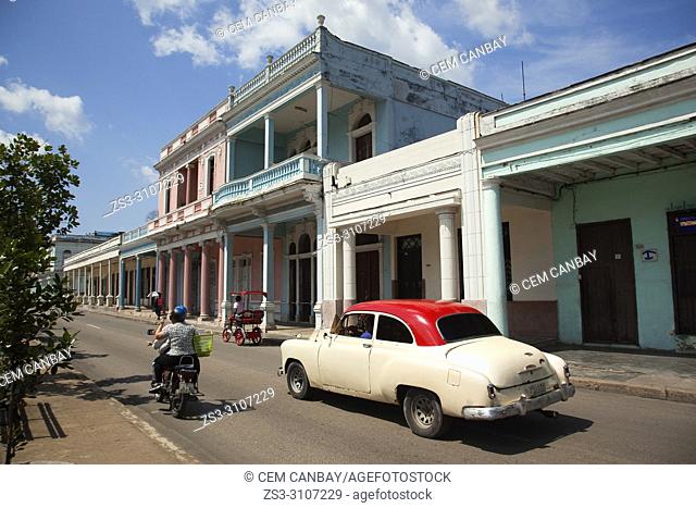 Old American car, motorcycle and bici taxi at Paseo Del Prado or so called Boulevard in the city center, Cienfuegos, Cuba, West Indies, Central America