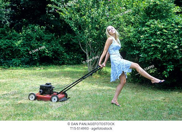Woman mowing lawn and dancing