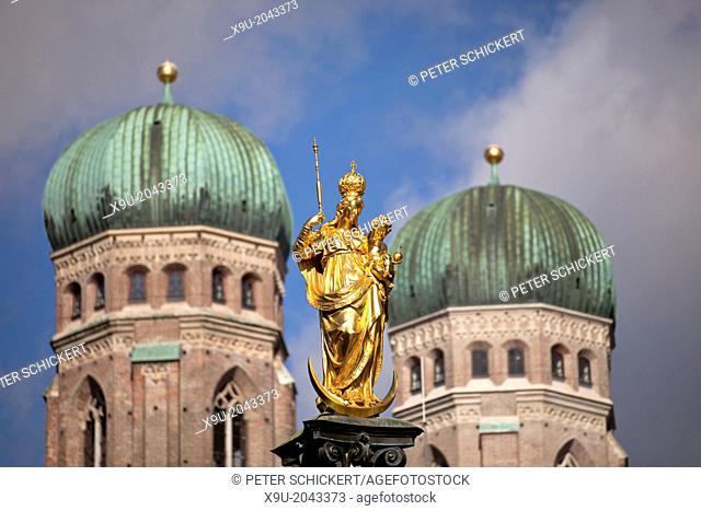 Virgin Mary atop the Mariensaeule and the church towers of the Frauenkirche in Munich, Bavaria, Germany