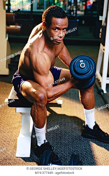 African American man curling weights