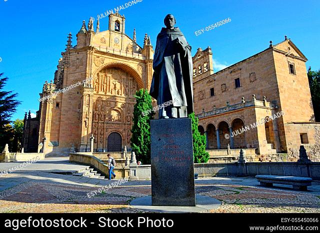 Salamanca, Spain - November 15, 2018: Sculpture of Father Francisco de Vitoria and the Convent of San Esteban in the background