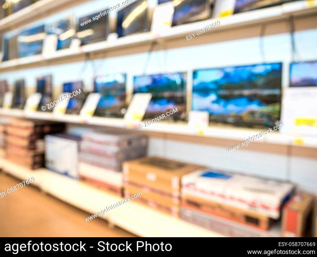 Blurred eletronic department store with television shelf. Blurred background with bokeh