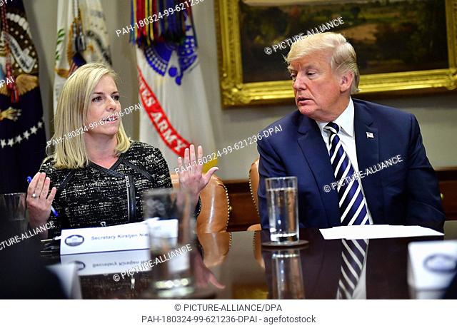 President Donald Trump (R) listens as Homeland Security Secretary Kirstjen Nielsen delivers remarks during a law enforcement roundtable on sanctuary cities