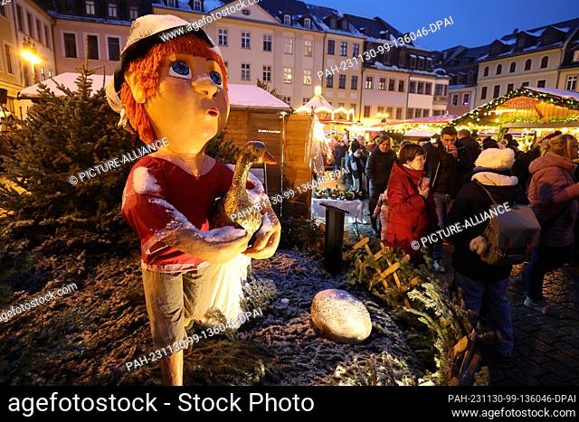 30 November 2023, Thuringia, Gera: Figures from the fairy tale ""Hans in Luck"" stand on the market square at the opening of the Christmas market