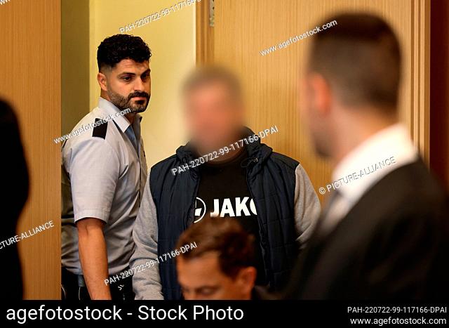 22 July 2022, North Rhine-Westphalia, Duesseldorf: The defendant is led into the courtroom. In the trial against the two alleged heads of a money counterfeiting...