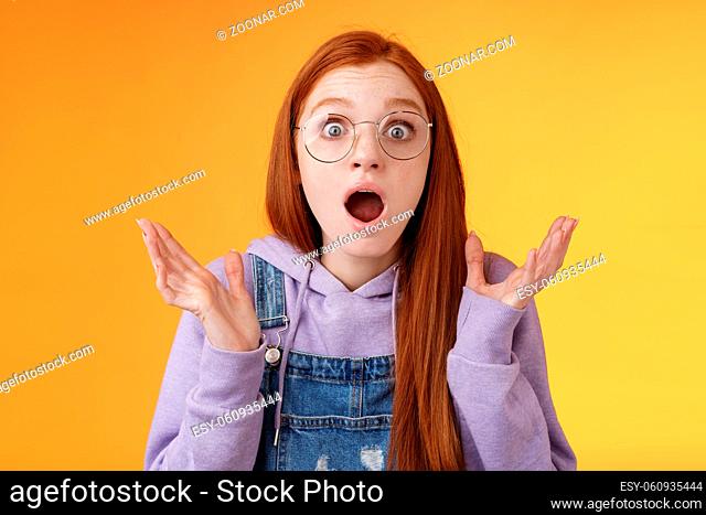 Close-up shocked sensitive concerned young panicking redhead woman worry drop jaw gasping raise hands spread freak out stare surprised emotional reacting...