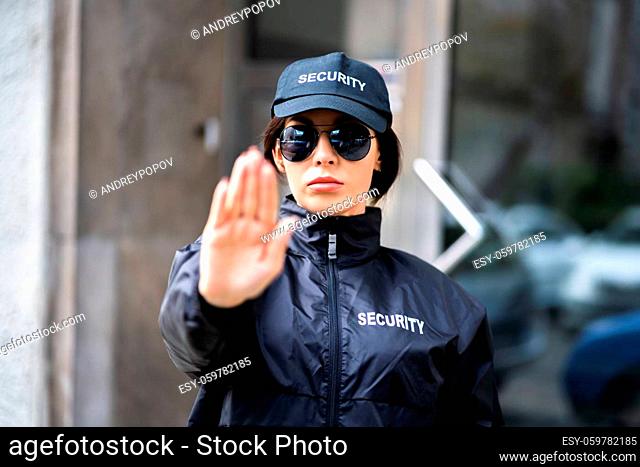 Confident Security Guard Making Stop Gesture Outside Building