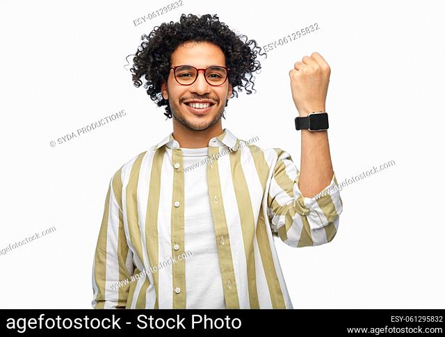 smiling young man in glasses showing smart watch