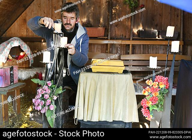 PRODUCTION - 27 November 2022, Saxony, Leipzig: Animal cemetery manager and mortician Mike Schmidt of the ""Frankenheimer Ruh"" animal cemetery lights candles...