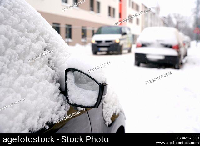 eingeschneite Autos in einer Straße in der Innenstadt von Magdeburg im Winter