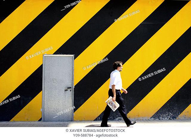 Man walking in front of striped wall