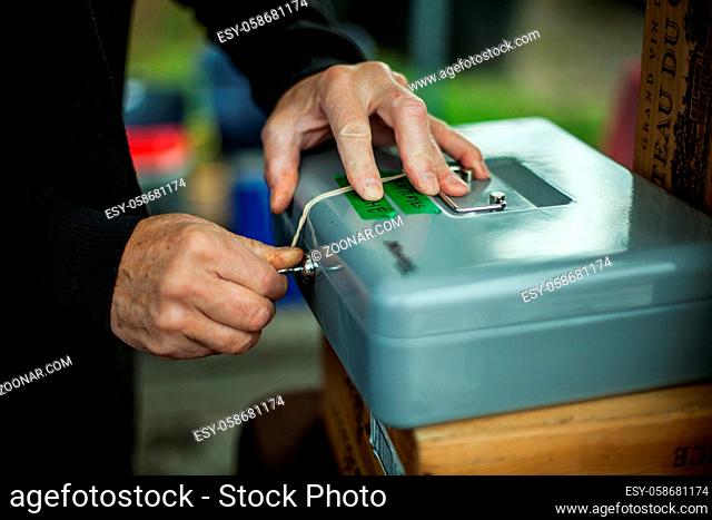 Hands locking a security box with a key