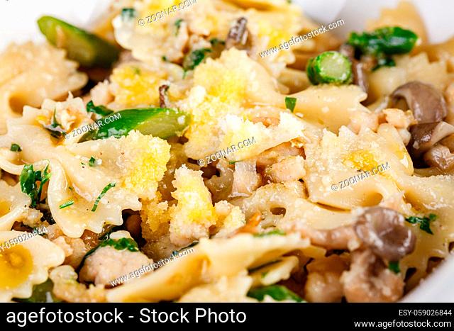 Farfalle pasta with champignon mushrooms, asparagus and garlic creamy sauce, close up