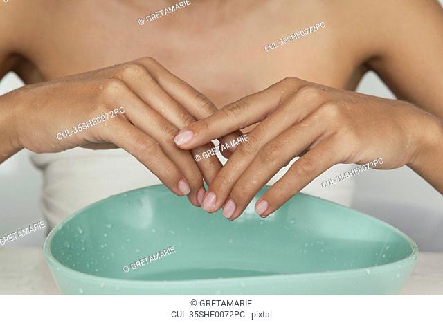 Woman's hands in bowl of water