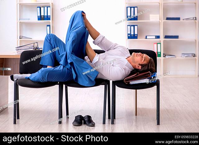 Young employee sleeping in the office on chairs