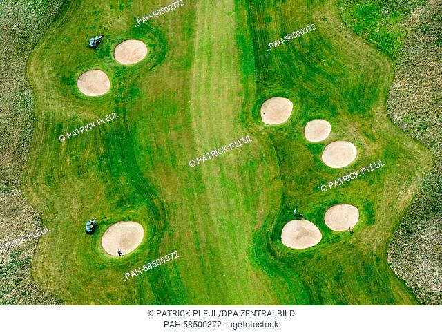 An aerial view shows a shows greenkeepers maintaining the fields and sand traps on the Faldo Course golf course in Bad Saarow, Germany, 19 May 2015