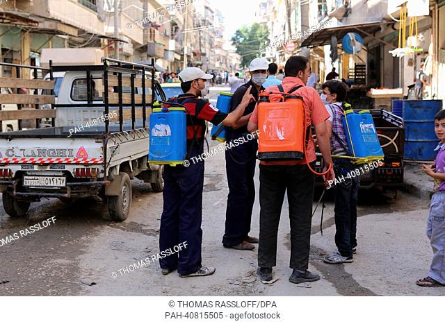 A group of men equipped with insecticides walk through the streets of Aleppo, Syria, 04 July 2013. Waste disposal management works irregularly